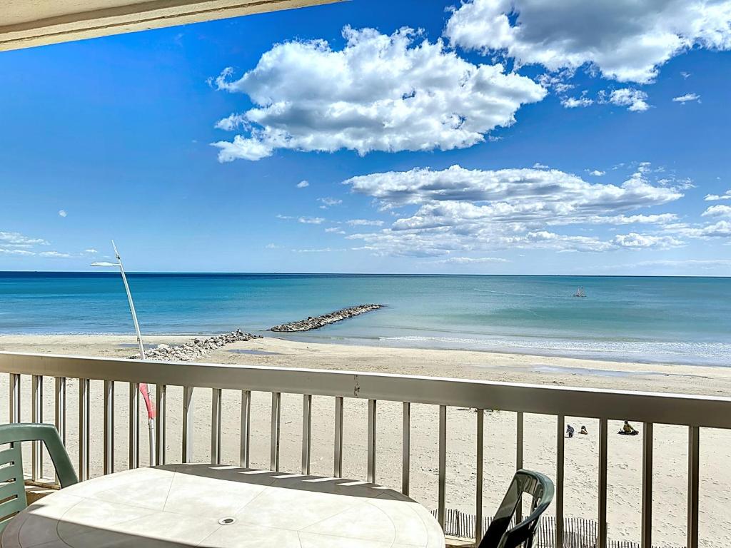 - une vue sur la plage dotée d'une table et de chaises dans l'établissement Bel Appartement F2 en 1ère Ligne avec Ascenseur - 4 Pers - Palavas-les-Flots - FR-1-715-88, à Palavas-les-Flots