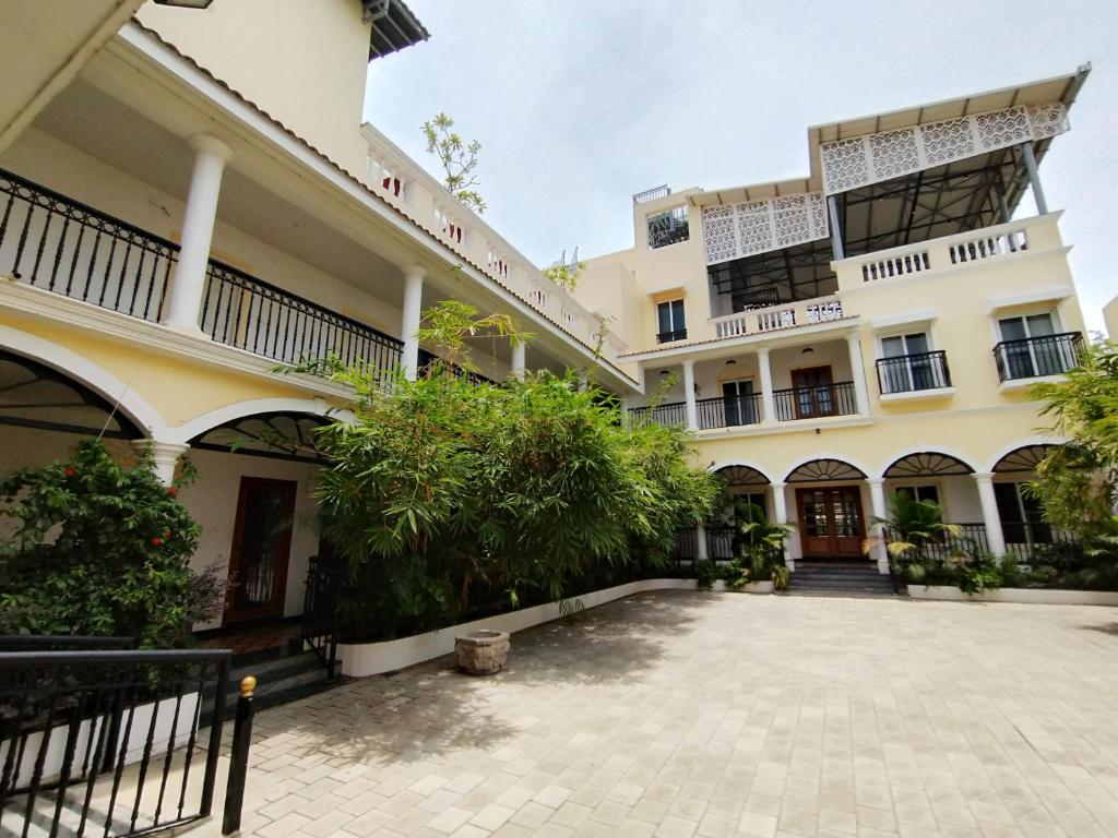 a building with a courtyard in front of it at Mayilveedu Guest House in Tuticorin