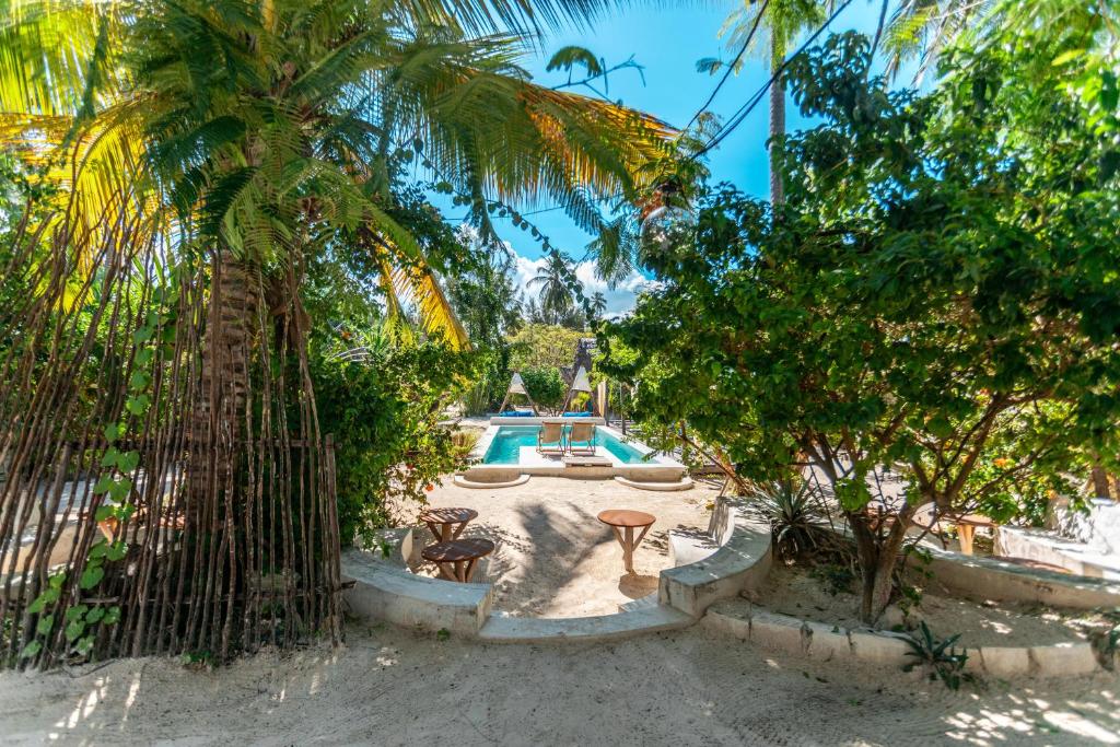 una valla con piscina en un patio con árboles en B4 Beach Club en Paje