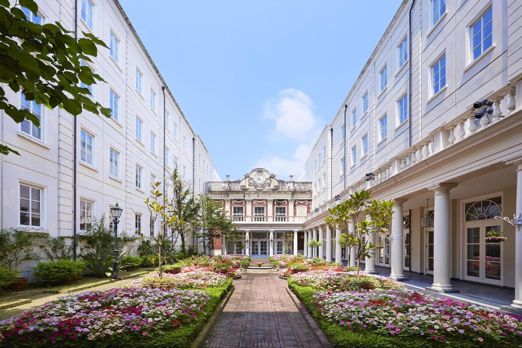 a walkway between two buildings with flowers at Hotel Amsterdam Huis Ten Bosch in Sasebo