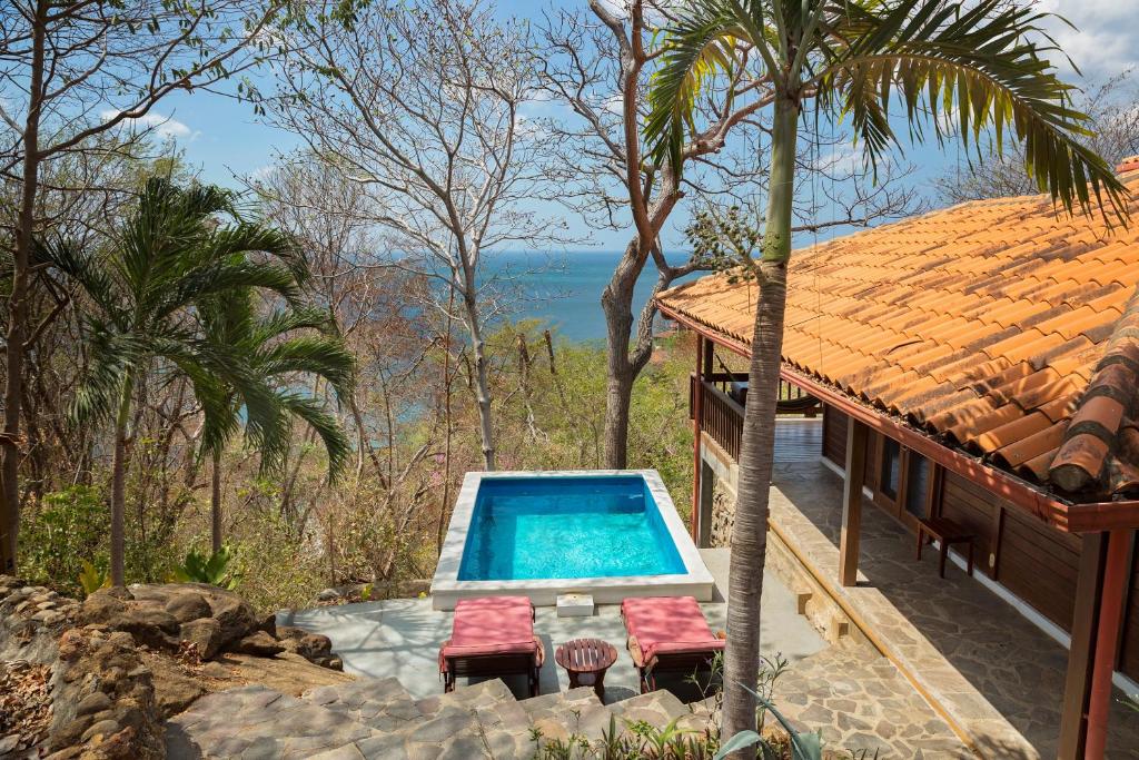 ein Haus mit einem Pool neben einem Resort in der Unterkunft Casa Amico Beach House in El Gigante