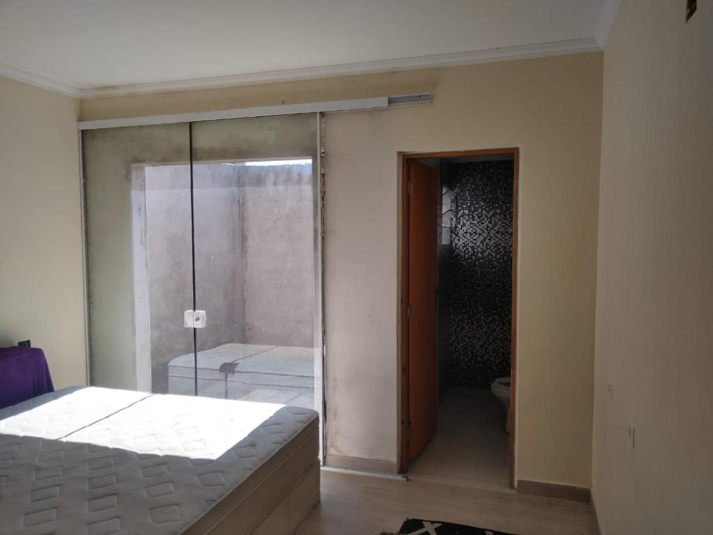 a bedroom with a shower and a bed and a toilet at Casa Tranquila em Itu in Itu