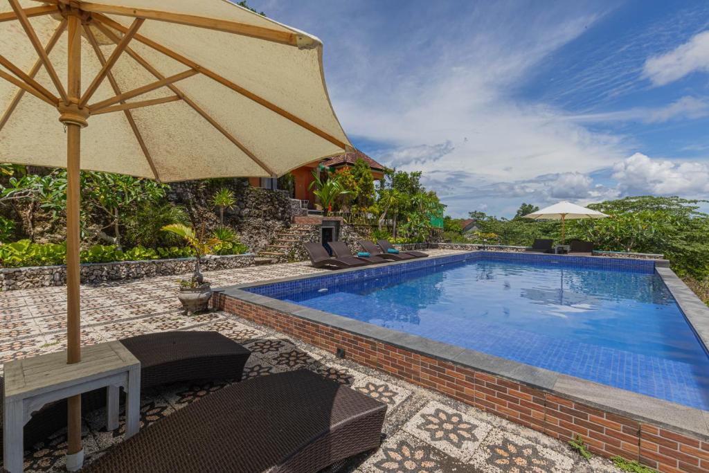 an umbrella sitting next to a swimming pool at La village hills view in Nusa Penida