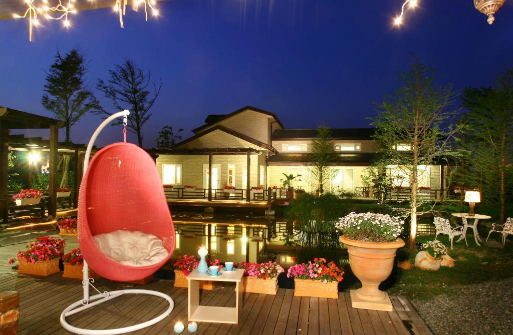 a backyard with a large red chair and a house at Spring Villa in Dongshan