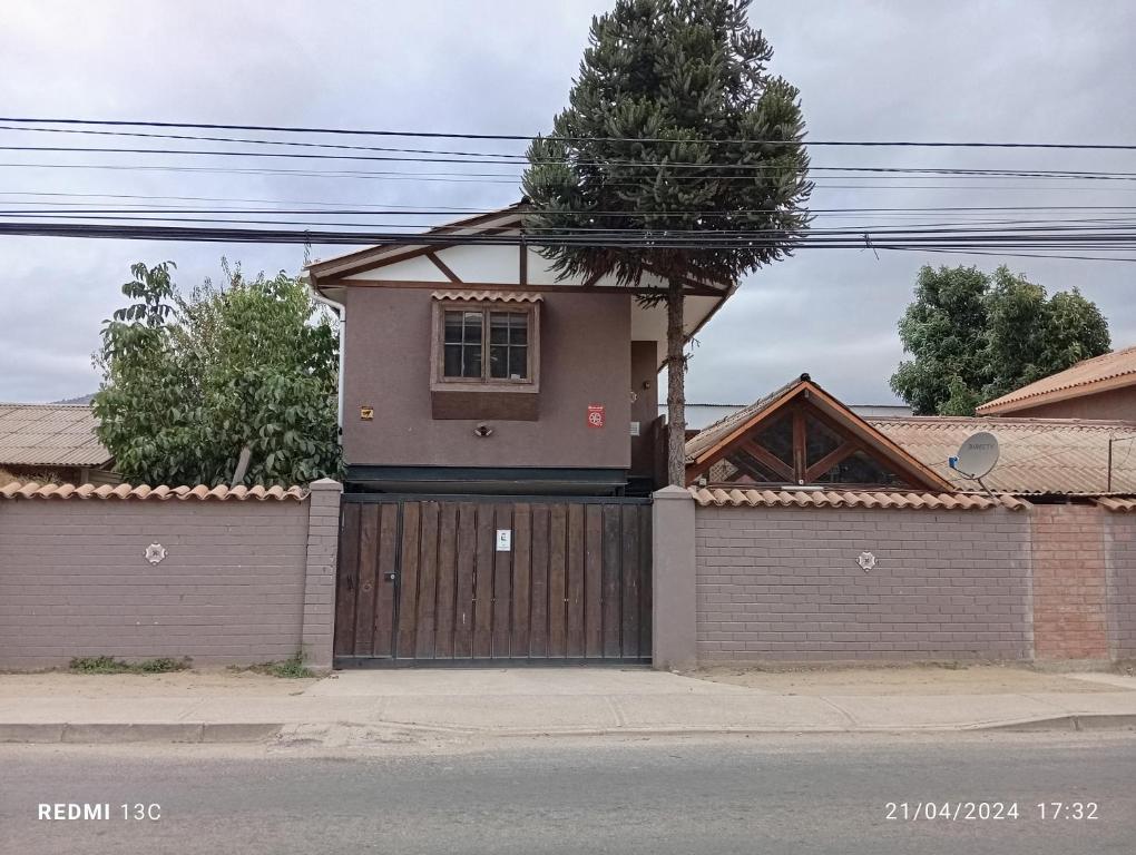 a house with a wooden gate and a garage at Alojamiento jv CABAÑA in Nogales