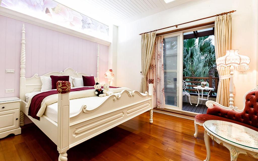 a white bedroom with a bed and a table at Spring Villa in Dongshan