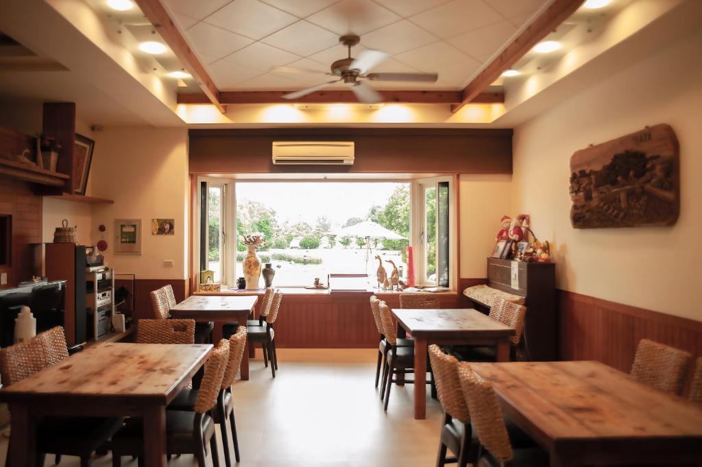 a restaurant with wooden tables and chairs and a large window at Spring Villa in Dongshan