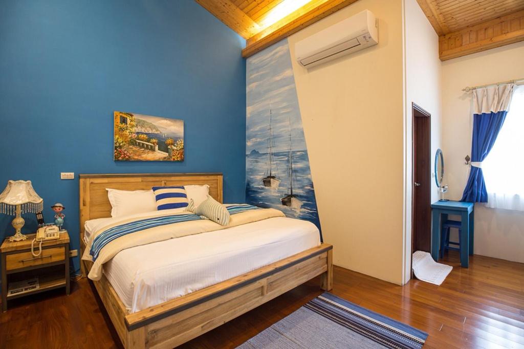 a bedroom with a bed with a blue wall at Spring Villa in Dongshan