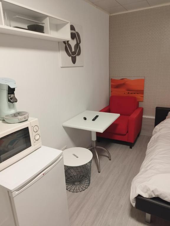 a small room with a microwave and a red couch at Modern Lux studio in Beringen