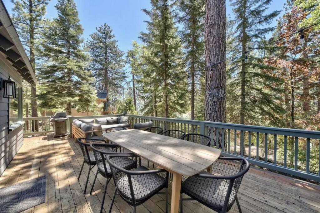 a deck with a wooden table and chairs at Spacious, Central, & Cozy Cabin Near Lake & Trails in Carnelian Bay