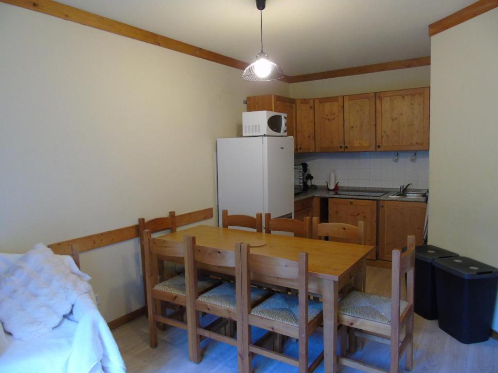 a kitchen with a table and chairs and a refrigerator at Appartement Valfréjus, 3 pièces, 8 personnes - FR-1-561-112 in Modane