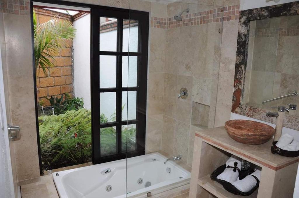 La salle de bains est pourvue d'une baignoire et d'un lavabo. dans l'établissement Hotel boutique sana, à Cuernavaca