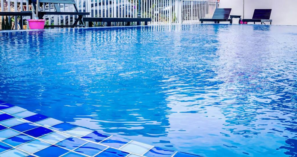 una piscina de agua azul en un edificio en Queens Backpackers Hostel, en Vang Vieng