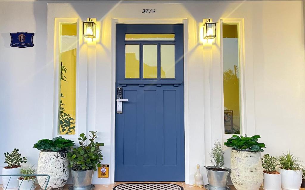 清邁的住宿－Ay’s House，栽有盆栽植物的房子上的蓝色门