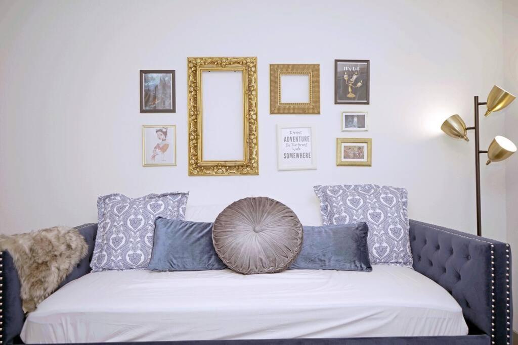 um sofá com almofadas azuis e um espelho na parede em Belle Suite -8mins from Disney, Centrally Located! em Anaheim