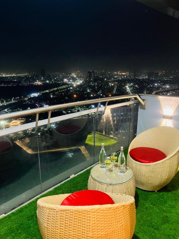 a balcony with two chairs and a table with wine glasses at The Luxury Lodge in Noida