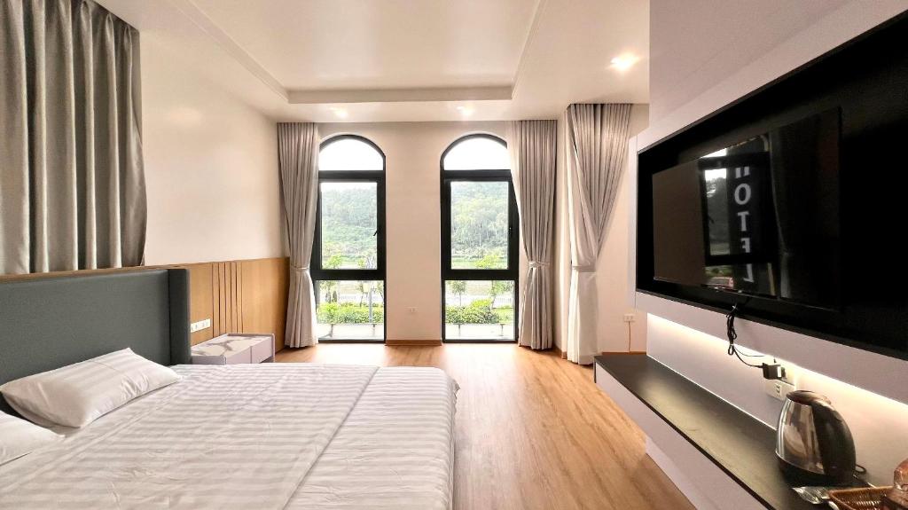 a bedroom with a bed and a flat screen tv at Golden Sea Hotel in Ðông Thôn