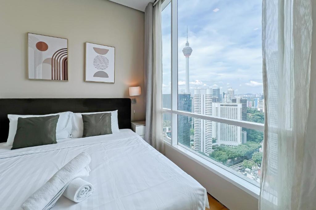 a bedroom with a white bed and a large window at Soho Suites KLCC by GuestHouse in Kuala Lumpur