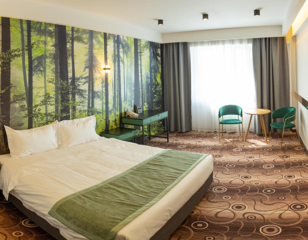 a hotel room with a bed and a forest mural at MB Hotel 