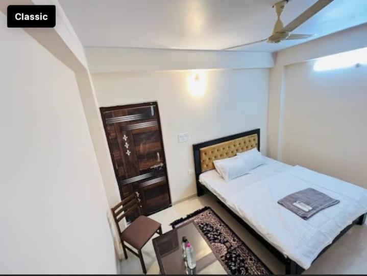 een kleine slaapkamer met een bed en een tafel bij Hotel Green Villa in Rewa