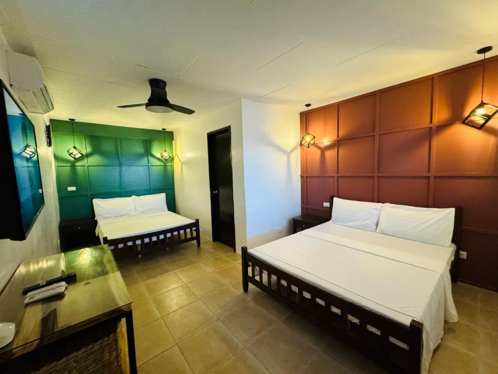 um quarto de hotel com duas camas e uma mesa em Casa Blanca em Puerto Galera
