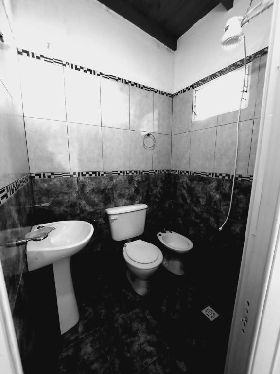 a black and white bathroom with a toilet and a sink at Surubí Sur in Goya