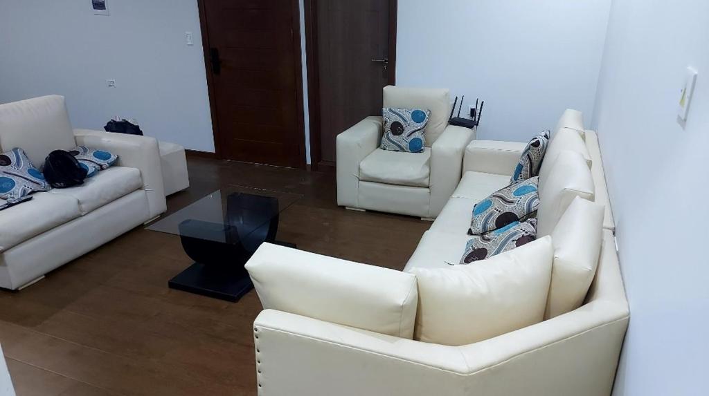 una sala de estar con sofás y sillas blancos en Hermoso y acogedor departamento, en Sucre