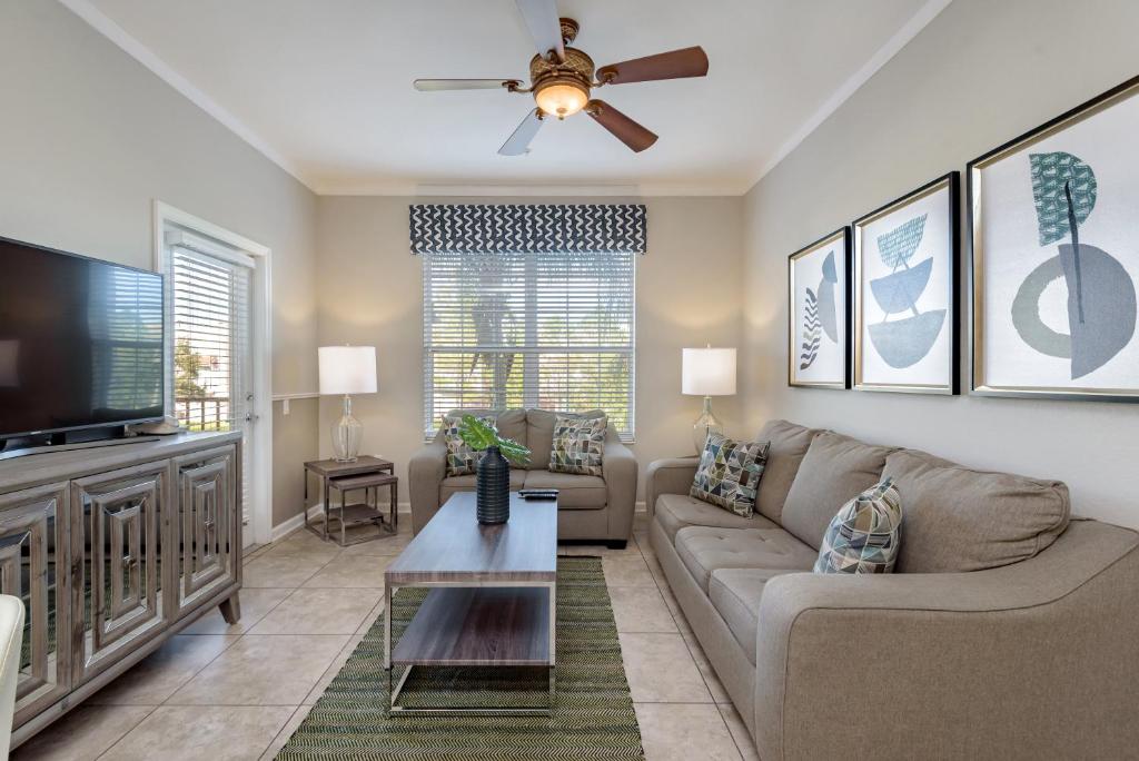 uma sala de estar com um sofá e uma televisão de ecrã plano em Vista Cay 65 by Top Villas em Orlando
