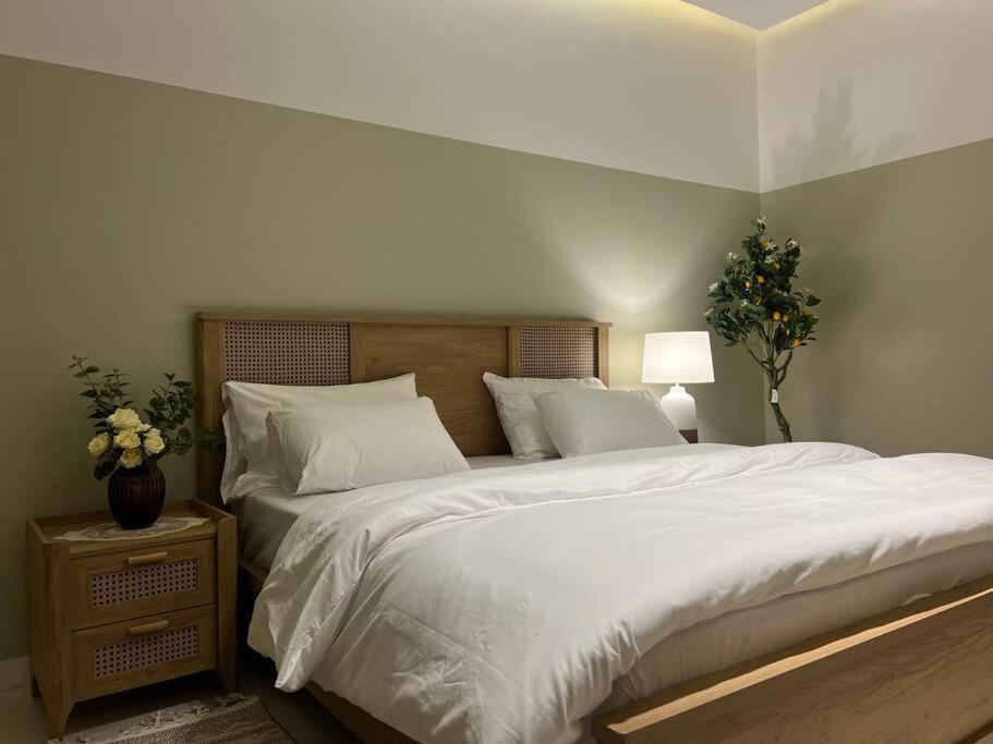 a bedroom with a large bed with white sheets and pillows at بوتيك هاوس بدخول ذاتي وصالة أنيقة in Hail