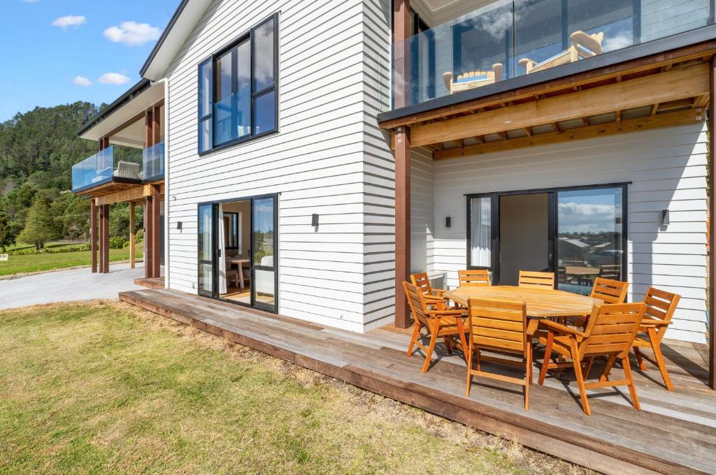 a patio with a wooden table and chairs on a house at The Terraces - Pauanui Holiday Home in Pauanui