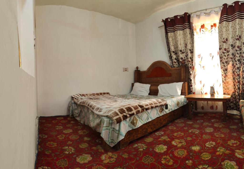 - une chambre avec un lit, une table et une fenêtre dans l'établissement Double tree irshad, à Srinagar