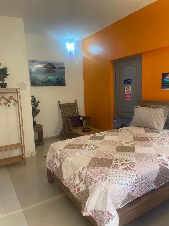 a bedroom with a large bed with an orange headboard at Location Chambres sur Bandrélé au sud de Mayotte chez Zam in Bandrélé