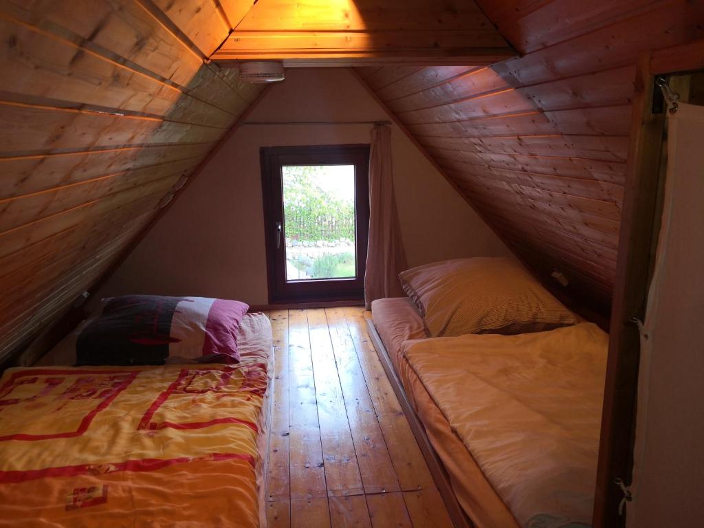 a attic room with two beds and a window at Zum Waldmeister in Schkeuditz