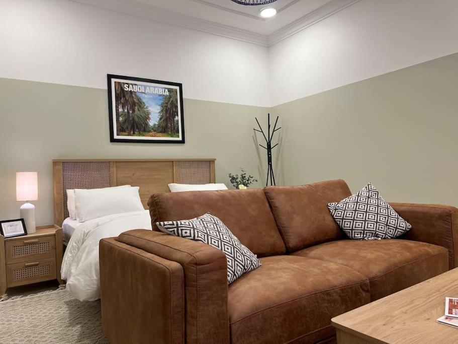 uma sala de estar com um sofá e uma cama em بوتيك هاوس بغرفة نوم أنيقة em Sidīs