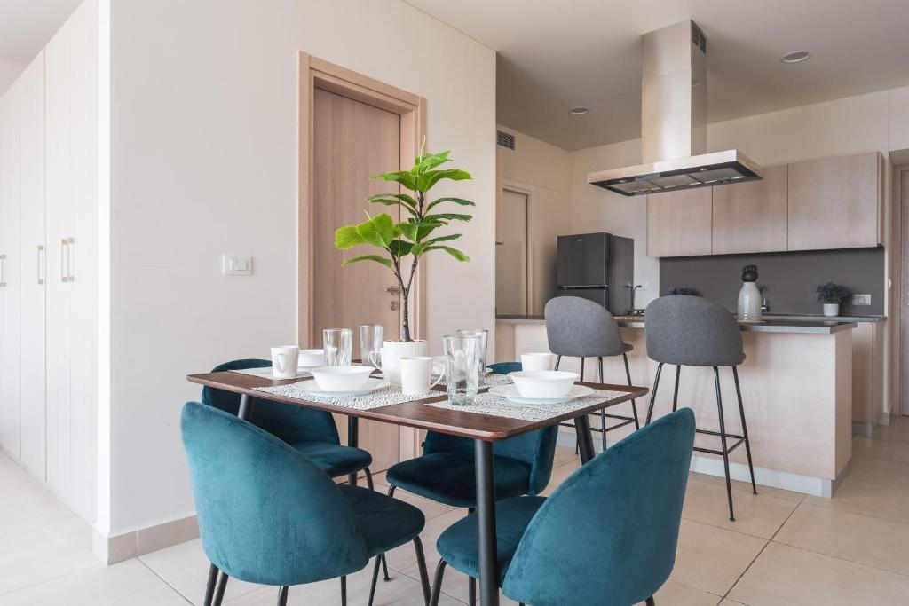 a dining room with a table and blue chairs at Isolda Suites Vistas del Bosque in Mexico City
