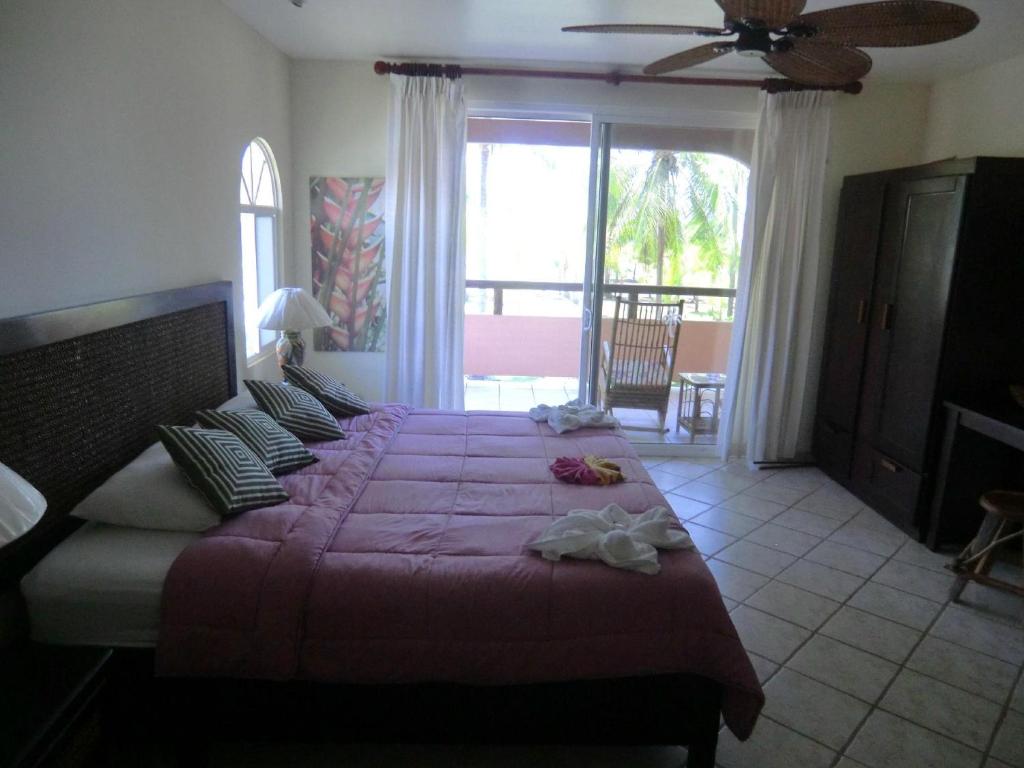 Un dormitorio con una cama grande con sábanas y almohadas púrpuras. en HOTEL COCOMAR, en Parrita
