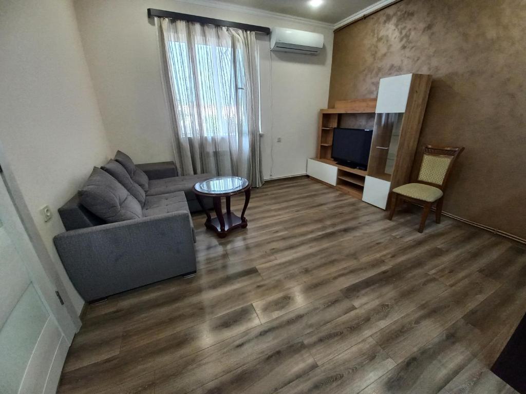 ein Wohnzimmer mit einem Sofa und einem TV in der Unterkunft Sahakyan's guest house in Yerevan