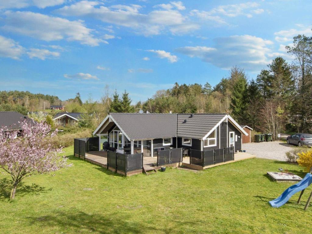a home with a large yard with a house at Holiday home Ebeltoft CXXXVI in Ebeltoft