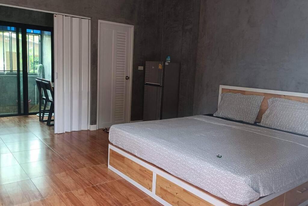 1 dormitorio con 1 cama en una habitación con mesa en Studio Apartment 12 in Thalang, en Ban Phak Chit