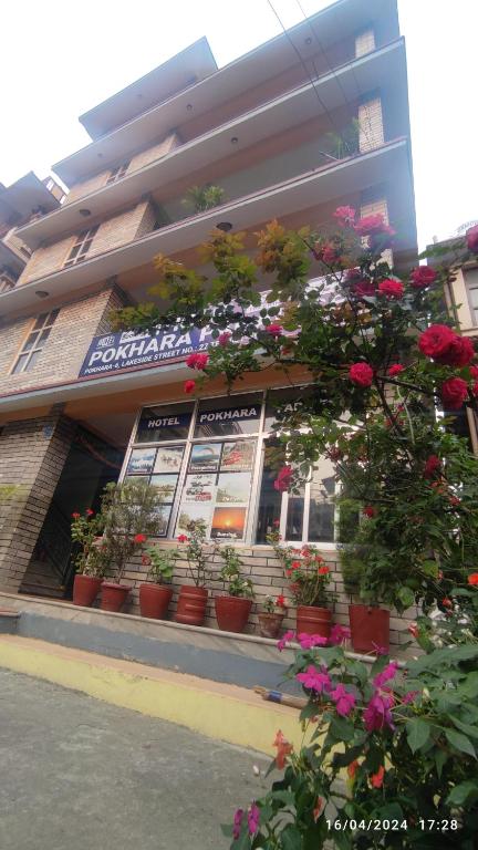 a building with potted flowers in front of a store at Hotel Pokhara Paradise in Pokhara