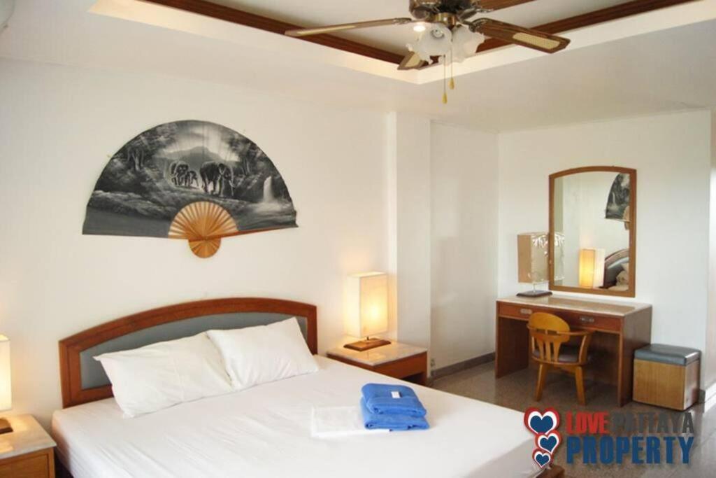 Un dormitorio con una cama y un escritorio con espejo. en 1. Studio at Somphong Ban Amphur beach Thailand, en Na Jomtien