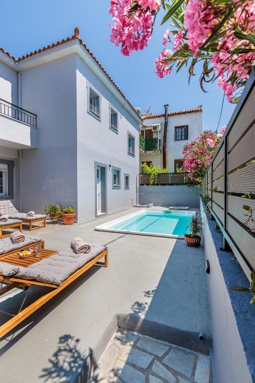 a courtyard with a swimming pool and a house at Forest view villa Skopelos in Skopelos Town