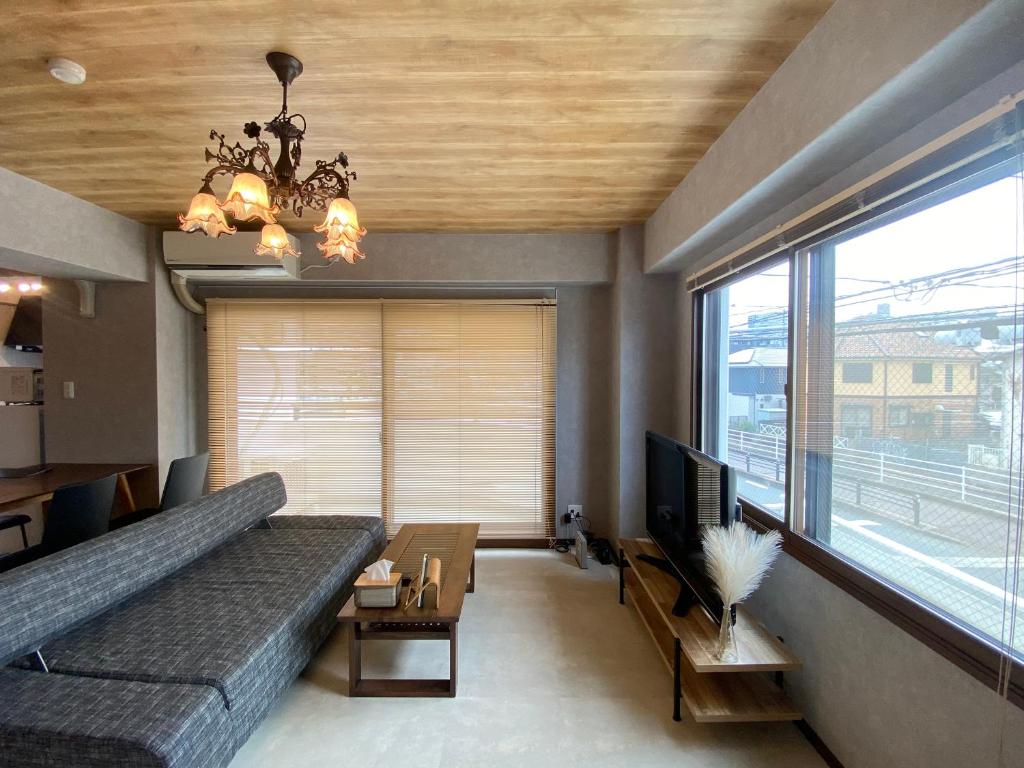 een woonkamer met een bank en een groot raam bij Suite Room PayPayヤフオクドーム Darinホークス通り2F in Fukuoka