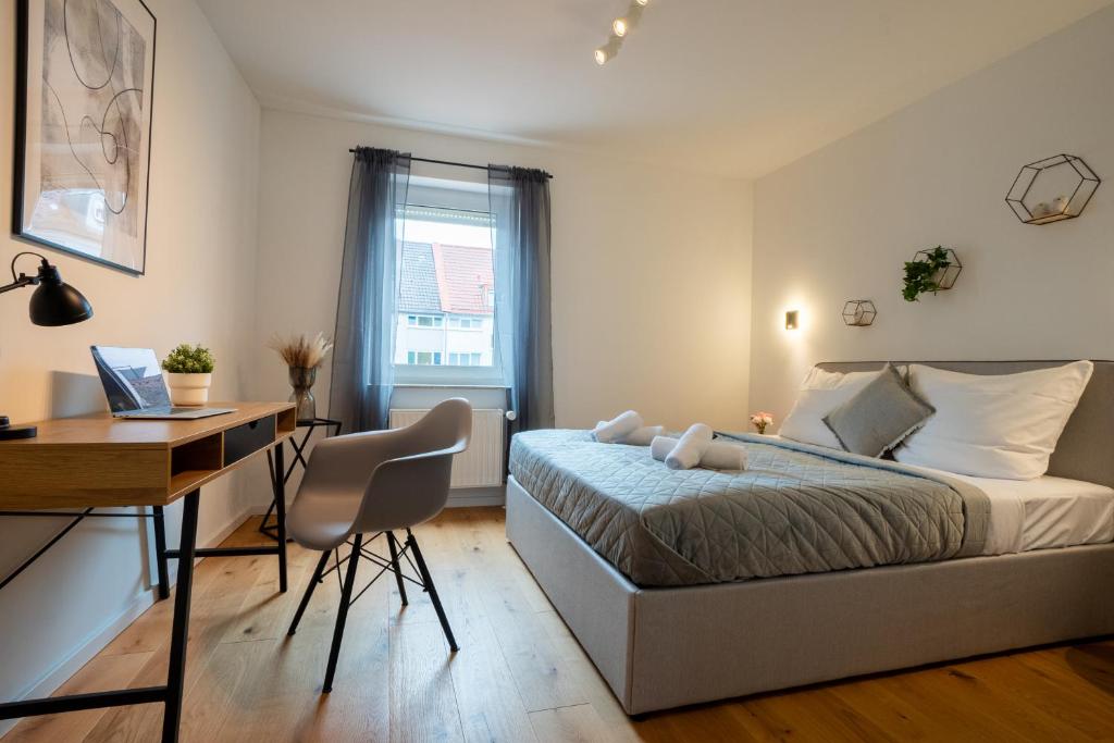 sypialnia z łóżkiem i biurkiem z komputerem w obiekcie Schlossberg Residences: City-Apartment im Herzen der Bergstrasse w mieście Bensheim