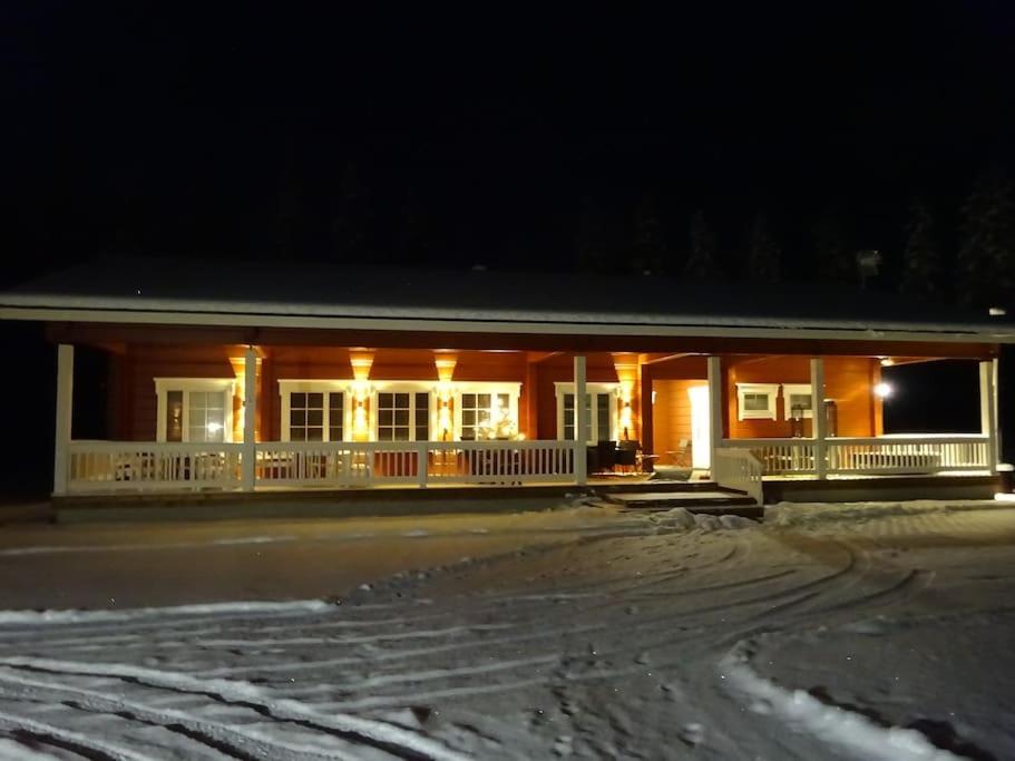 un edificio con luces encendidas en la nieve por la noche en Wonderful Holiday home, en Kivitaipale