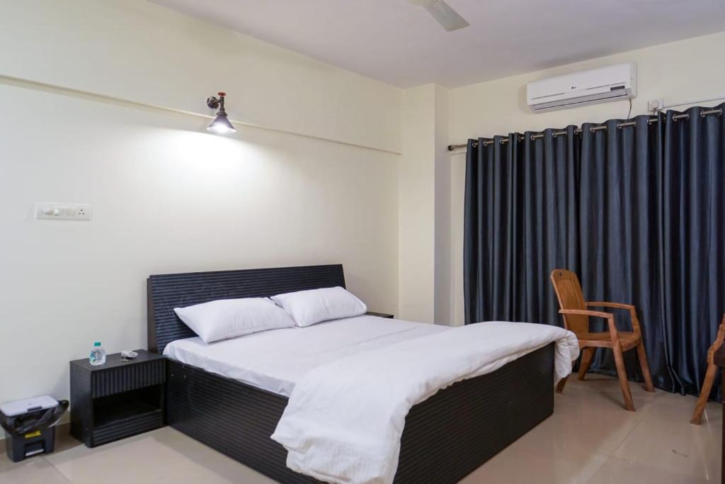 a bedroom with a bed and a chair in it at AP's Castle Stay in Kharadi