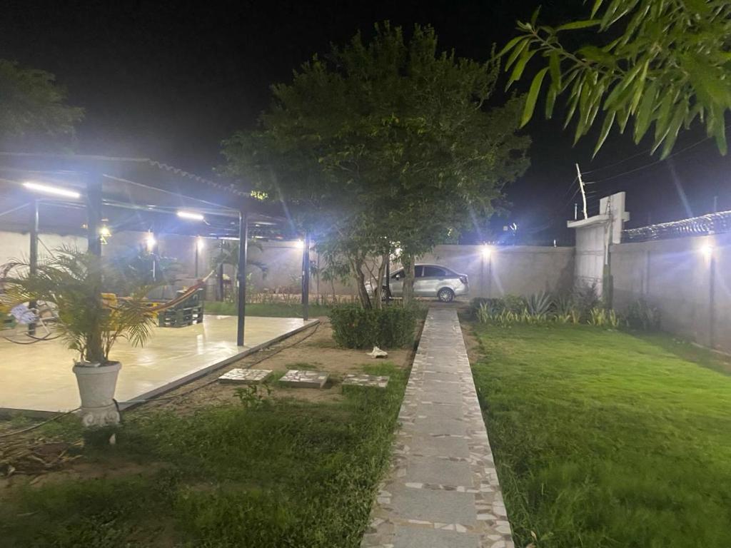 un parking de nuit avec une voiture garée dans une cour dans l'établissement 2 HABITACIONES EN CASA CAMPO GUACOCHE - 8PERSONAS A 12 MINUTOS DE VALLEDUPAR, CERCA PARQUE DE LA LEYENDa, à Valledupar