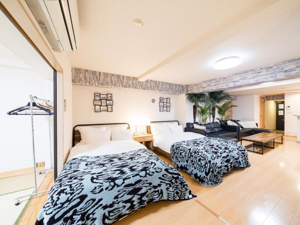 a bedroom with two beds and a living room at Shinjuku, 1min walk from Kagurazaka Sta ,80square meters,net, PocketWiFi, Switch in Tokyo
