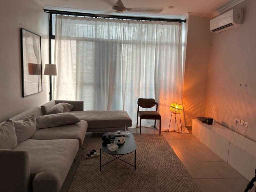 - un salon avec un canapé et une fenêtre dans l'établissement Amaan, à Dar es Salaam