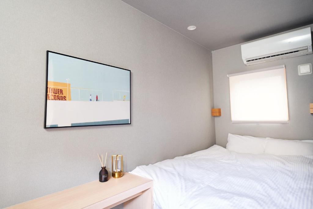 una camera da letto con TV appesa al muro di Boxi hakata 1 - Vacation STAY 61823v a Sumiyoshi